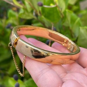 Gold tone oval hinged bangle bracelet